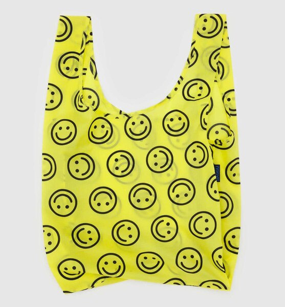 Yellow reusable BAGGU bag with allover black smiley face pattern